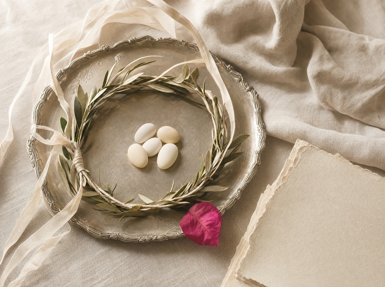 A stefana crown and koufeta styled on linen, a detail for the day